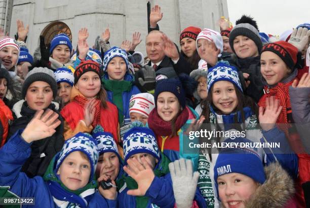 Russian President Vladimir Putin meets with children as they gather for a New Year performance at the Kremlin's Sobornaya Square in Moscow on...