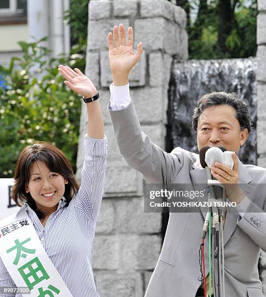 Japan's main opposition Democratic Party of Japan leader Yukio Hatoyama raises hands with his party's young female candidate Kazumi Ota at a rally...