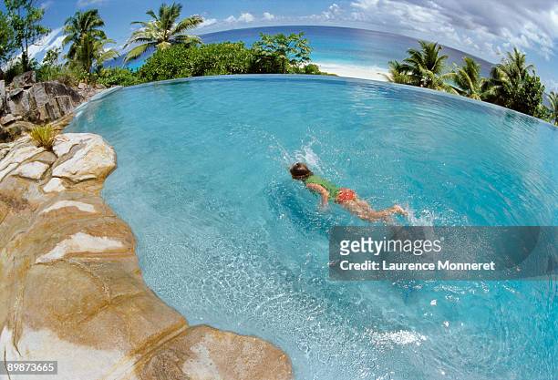 young boy swimming in a tropical pool above sea - paradisiaque - fotografias e filmes do acervo
