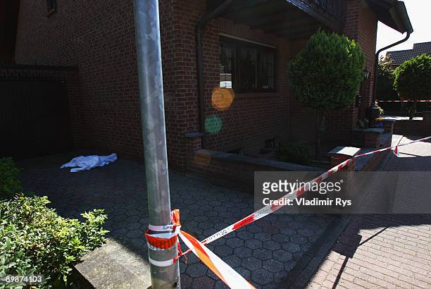 Blood marking on one of the victims is covered by a tilt on the crime scene on August 19, 2009 in Schwalmtal near Duesseldorf, Germany. A German...
