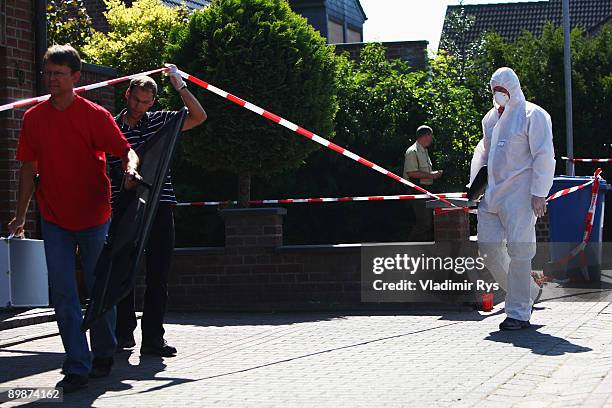 Policemen investigate the crime scene on August 19, 2009 in Schwalmtal near Duesseldorf, Germany. A German pensioner is in police custody after...