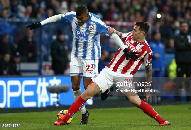 Collin Quaner of Huddersfield Town battles for possesion with Geoff Cameron of Stoke City during the Premier League match between Huddersfield Town...