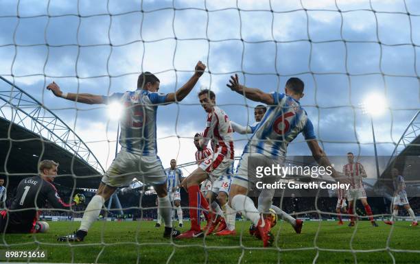 Peter Crouch of Stoke City shoots but has the ball played of the line by Chris Lowe of Huddersfield Town and Jonathan Hogg of Huddersfield Town...