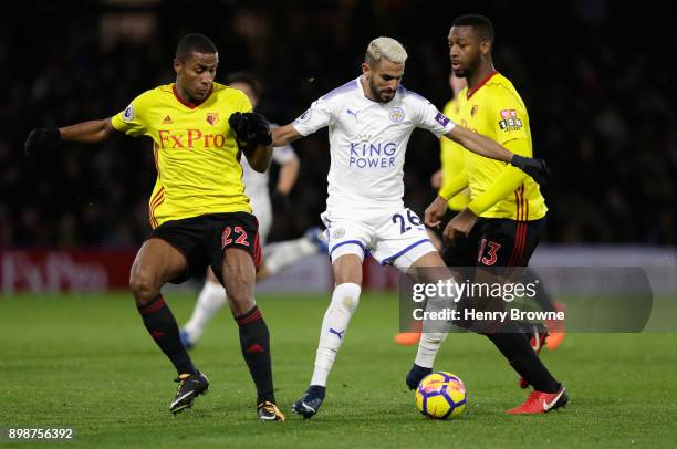 Riyad Mahrez of Leicester City is challenged by Marvin Zeegelaar and Molla Wague of Watford during the Premier League match between Watford and...