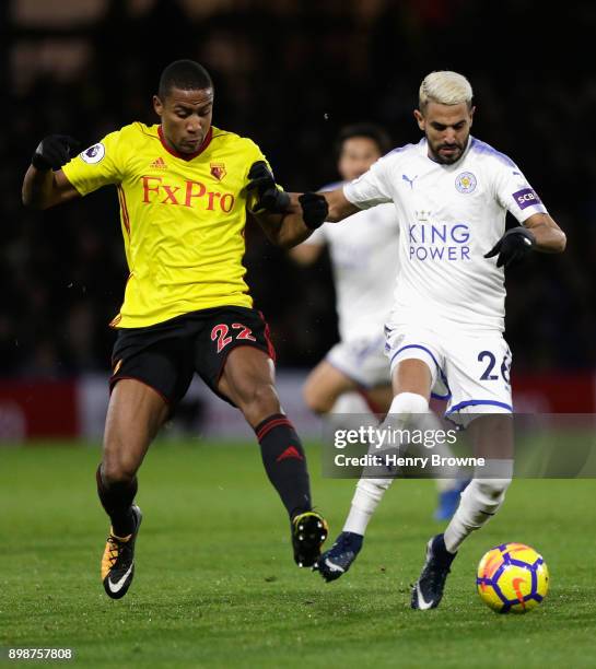 Riyad Mahrez of Leicester City is challenged by Marvin Zeegelaar of Watford during the Premier League match between Watford and Leicester City at...