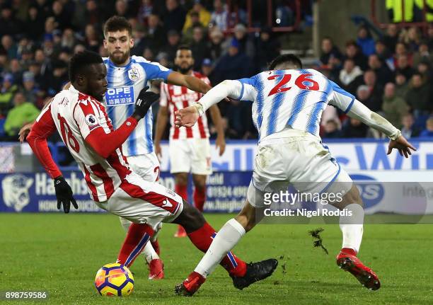 Mame Biram Diouf of Stoke City is tackled by Christopher Schindler of Huddersfield Town in the penalty area but no penalty is awarded during the...