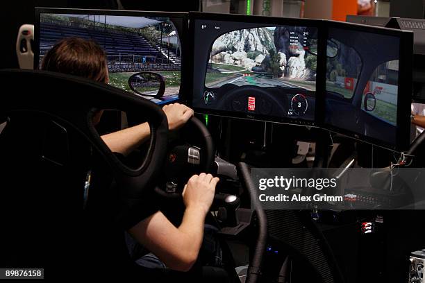 Visitors plays' Forza Motorsport 3' at the xbox 360 stand of U.S. Computer and technology corporate Microsoft during the 'gamescom', Europe's biggest...