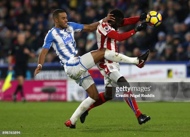 Mame Biram Diouf of Stoke City and Mathias Jorgensen of Huddersfield Town battle for possesion and Mame Biram Diouf of Stoke City handles the ball...