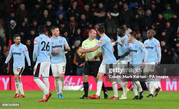 Match referee Bobby Madley is surrounded by West Ham United players after awarding AFC Bournemouth a third goal during the Premier League match at...