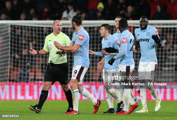 Match referee Bobby Madley is surrounded by West Ham United players after awarding AFC Bournemouth a third goal during the Premier League match at...