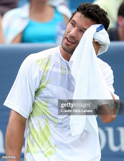 Jose Acasuso of Argentina wipes sweat from his facing during his loss to Roger Federer of Switzerland during day three of the Western & Southern...