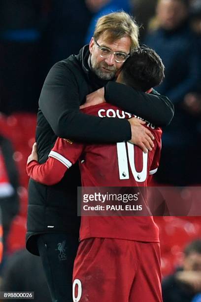 Liverpool's German manager Jurgen Klopp hugs Liverpool's Brazilian midfielder Philippe Coutinho applauds after the final whistle during the English...