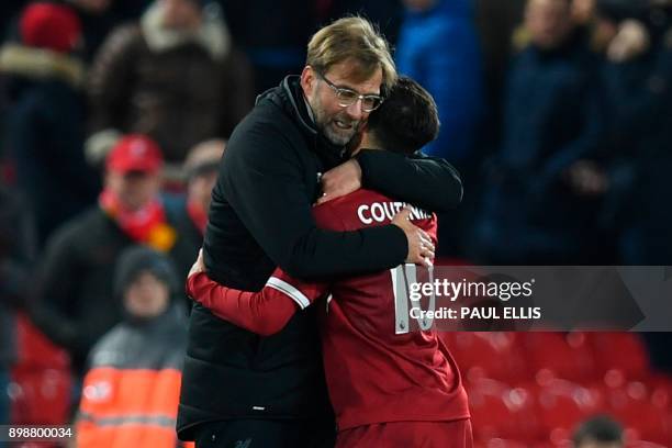 Liverpool's German manager Jurgen Klopp hugs Liverpool's Brazilian midfielder Philippe Coutinho applauds after the final whistle during the English...
