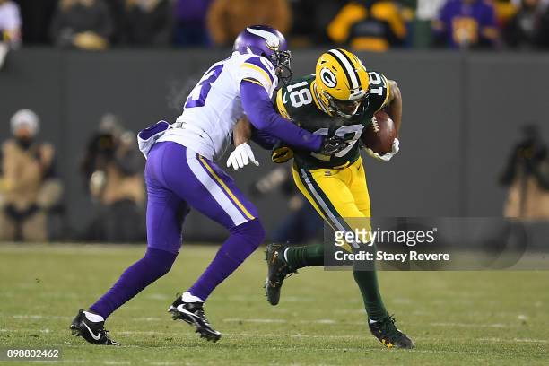 Randall Cobb of the Green Bay Packers is brought down by Terence Newman of the Minnesota Vikings during a game at Lambeau Field on December 23, 2017...