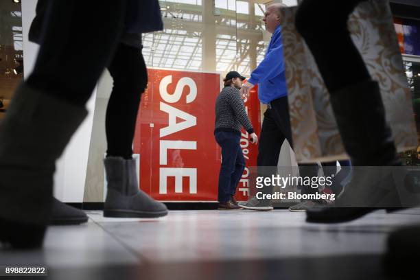 Shoppers walk past a "Sale" sign at the Easton Town Center Mall in Columbus, Ohio, U.S., on Tuesday, Dec. 26, 2017. Americans displayed their buying...