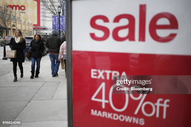 Shoppers walk past a "Sale" sign at the Easton Town Center Mall in Columbus, Ohio, U.S., on Tuesday, Dec. 26, 2017. Americans displayed their buying...