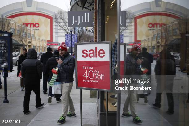 Shopper carries bags while walking past a "Sale" sign at the Easton Town Center Mall in Columbus, Ohio, U.S., on Tuesday, Dec. 26, 2017. Americans...