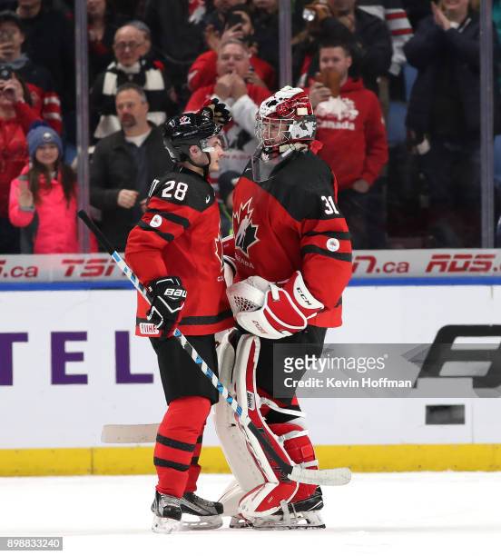 Victor Mete of Canada congratulates Carter Hart after winning the game against Finland at KeyBank Center on December 26, 2017 in Buffalo, New York....