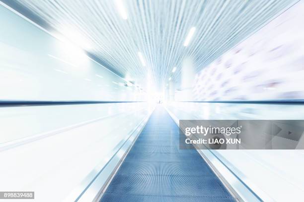 person with suitcase on a moving escalator - lonely businessman alone late at work stock pictures, royalty-free photos & images