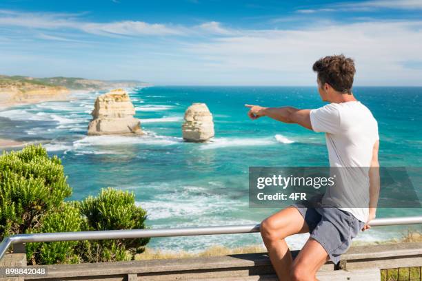 touristen, die mit blick auf die 12 apostel, great ocean road, australien - the twelve apostles australische kalksteinfelsen stock-fotos und bilder