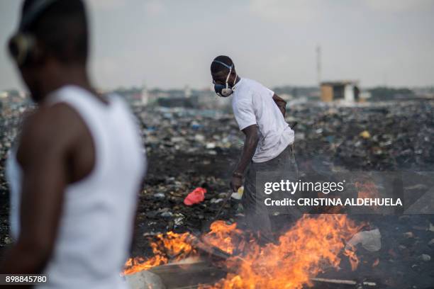 Young men burn e-waste at Agbogbloshie dumpsite in Accra on November 29, 2017. - The dumpsite is located in Agbogbloshie slum, a former wetland in...