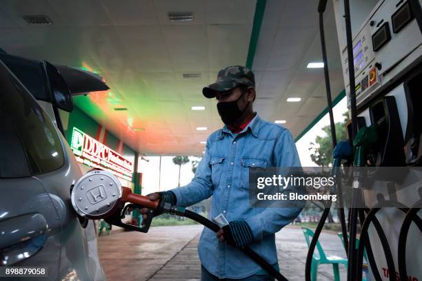 Man uses a fuel pump to fill up a car at a gas station in Dawei, Myanmar, on Friday, Dec. 22, 2017. As the U.S. And Europe grow increasingly outraged...