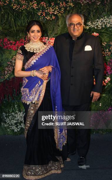 Indian Bollywood actress Sridevi and husband Boney Kapoor pose for a photograph during the wedding reception of the Bollywood actress Anushka Sharma...