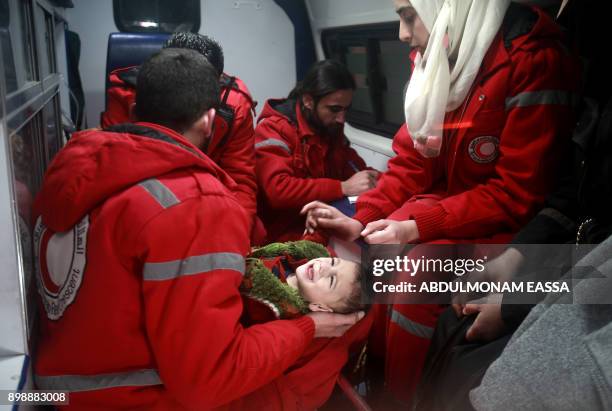 Syrian staff from the International Committee of the Red Cross evacuate a baby in Douma in the eastern Ghouta region on the outskirts of the capital...