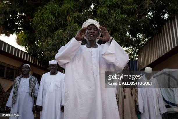Relatives of Oumar Garba , passing through Birao, northern Central African Republic, pray as they visit him at home on October 20, 2017. - Oumar...