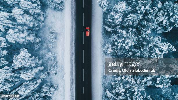 luftaufnahme der straße im winter mit roten auto drauf - winter stock-fotos und bilder