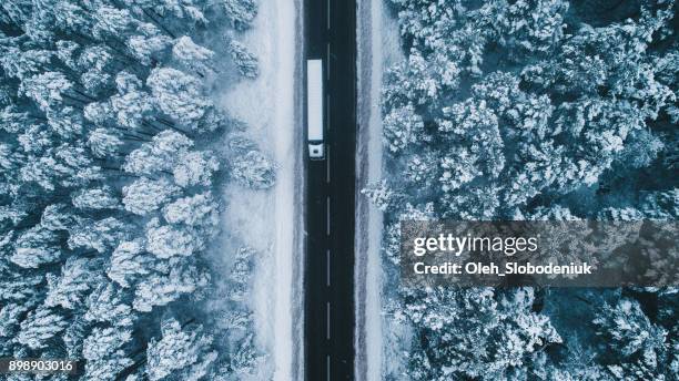 aerial view of road in winter with truck on it - christmas truck stock pictures, royalty-free photos & images