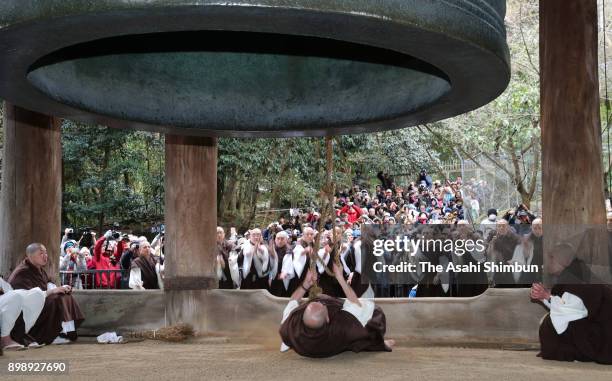 Buddhist priest from Chionin temple tug a huge wooden bell hammer to ring the temple's giant bell as fellow priests cling onto the ropes on December...