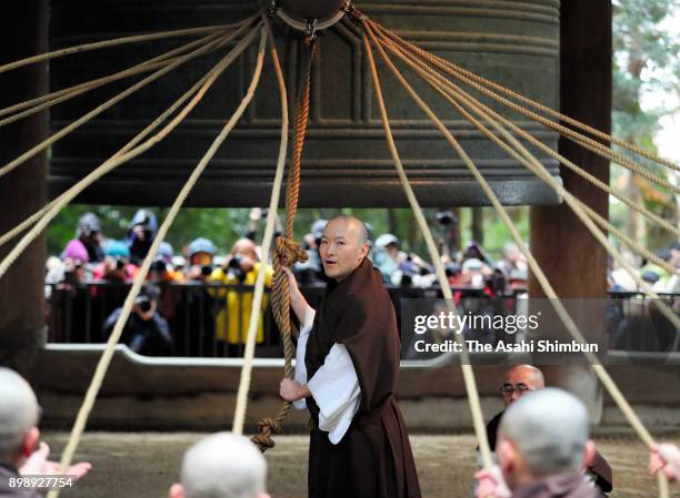 Buddhist priest from Chionin temple prepares to tug a huge wooden bell hammer to ring the temple's giant bell as fellow priests cling onto the ropes...