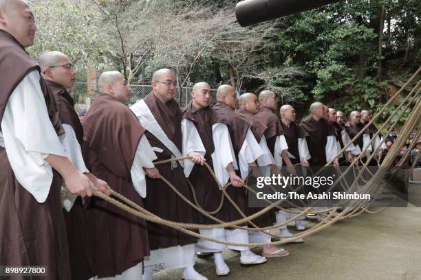 Buddhist priest from Chionin temple tug a huge wooden bell hammer to ring the temple's giant bell as fellow priests cling onto the ropes on December...