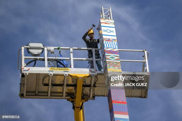 Man helps fix the top of a LEGO tower under construction in Tel Aviv on December 27 as the city attempts to break Guinness world record of the...