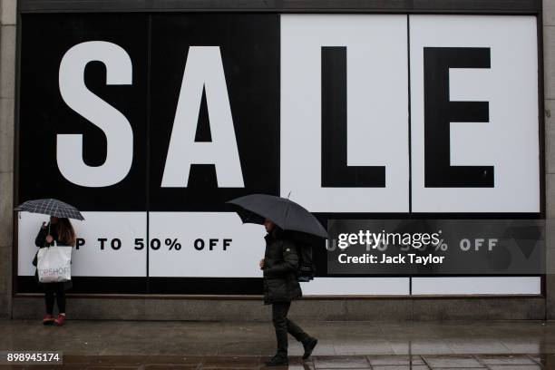 Shoppers walk past a 'Sale' sign on Oxford Street on December 27, 2017 in London, England. Fewer people have hit the high street for the...