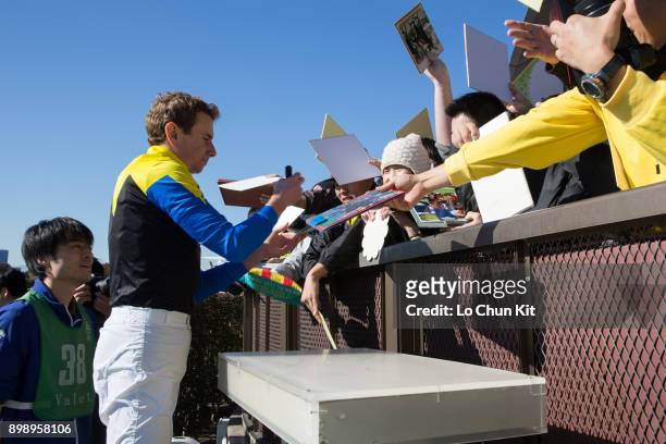 Ryan Moore gives his autograph to Japanese racing fans after he reaching 100th JRA victory at Tokyo Racecourse on November 25, 2017 in Tokyo, Japan.