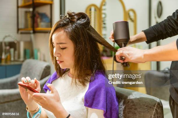 femme, obtenir ses cheveux coiffés au salon de coiffure - dry hair photos et images de collection