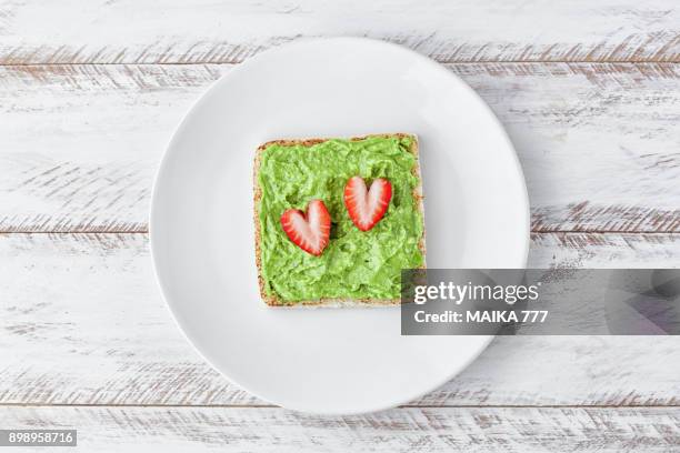 avocado toast with strawberries - avocado toast white background stockfoto's en -beelden