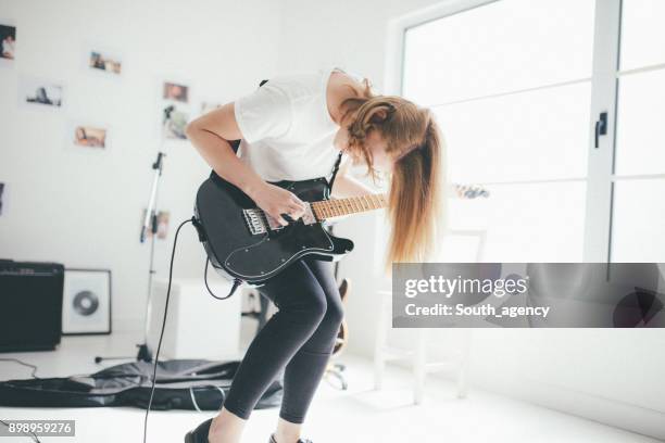 beautiful young woman playing electric guitar - headbanging stock pictures, royalty-free photos & images