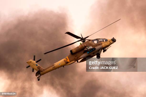 An Israeli AH-64 Apache longbow helicopter performs during an air show at the graduation ceremony of Israeli air force pilots at the Hatzerim Israeli...