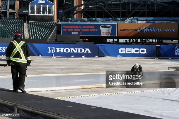 Workers tend to the auxiliary rink as the rink build process continues at Citi Field ahead of the 2018 Bridgestone NHL Winter Classic between the...