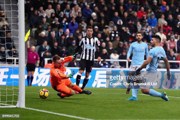 Sergio Aguero of Manchester City plays the ball past Rob Elliot of Newcastle United into the net before his goal is ruled out for offside during the...