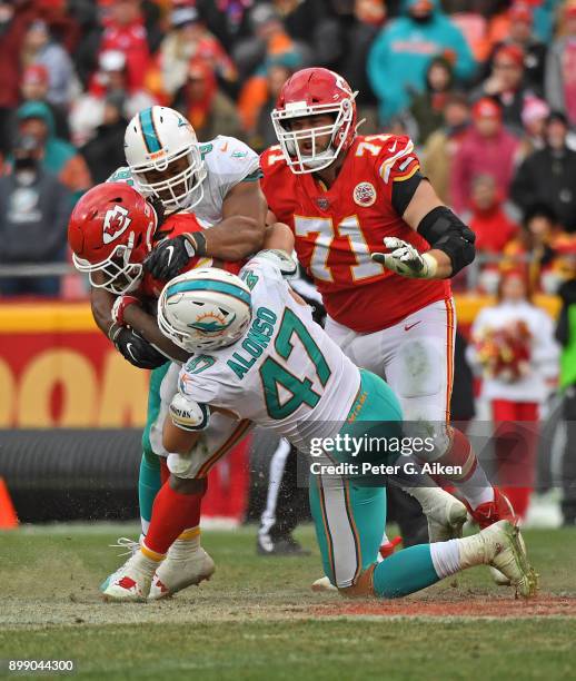 Middle linebacker Kiko Alonso and defensive end Cameron Wake of the Miami Dolphins tackle running back Kareem Hunt of the Kansas City Chiefs during...