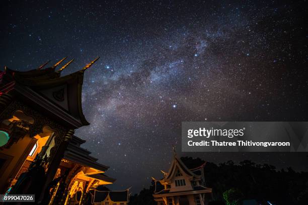 milky way galaxy with bright stars and space dust of thai temple ,the northeast of thailand : wat pa phu kon - udon thani stockfoto's en -beelden