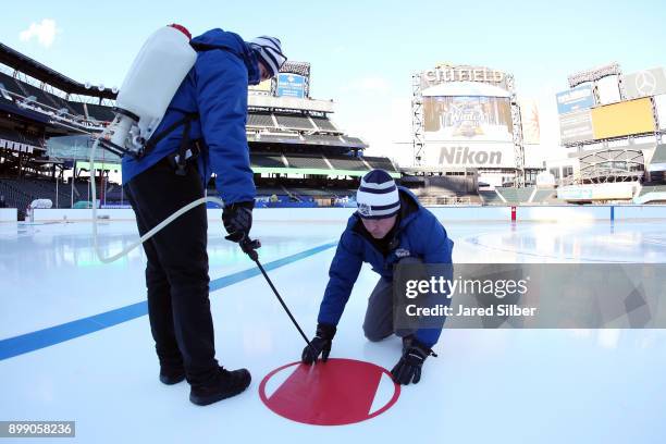 Members of the ice crew install the lines and logos as the rink build process continues at Citi Field ahead of the 2018 Bridgestone NHL Winter...