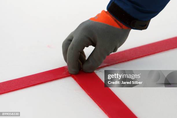 The lines and logos get installed as the rink build process continues at Citi Field ahead of the 2018 Bridgestone NHL Winter Classic between the...