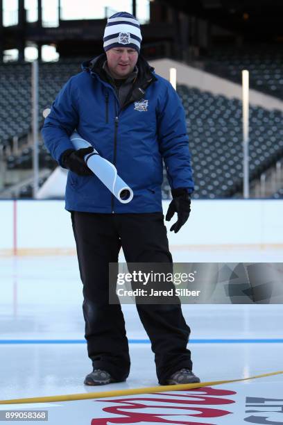 Mike Craig, NHL Senior Manager, Facilities Operations & Hockey Operations, oversees the install of the lines and logos as the rink build process...