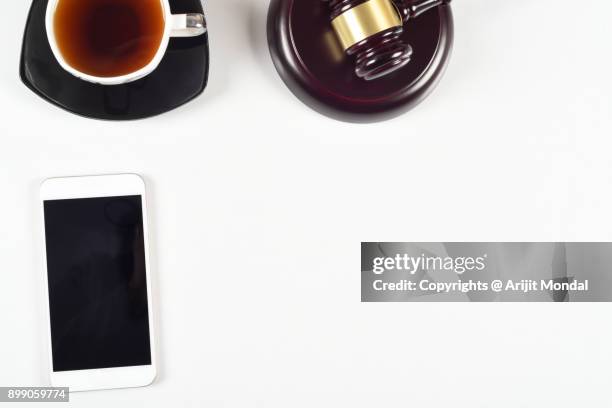 close view of law officers white wooden office table with smart phone, judges gravel, black tea flat lay copy space - bid paddle stock pictures, royalty-free photos & images