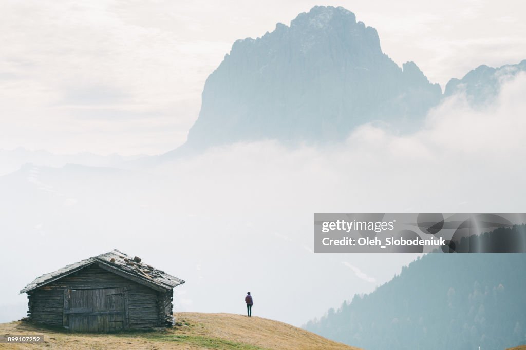 Man die in de buurt van de hut met uitzicht op de bergen van de Dolomieten, Italië
